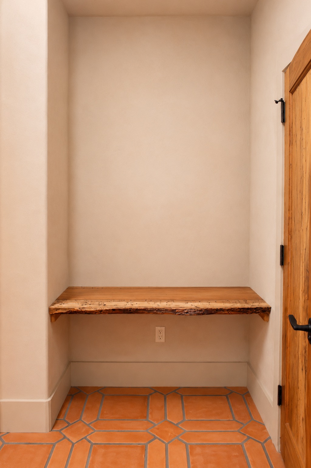 Mudroom nook with a natural-edge wood shelf and tile floor
